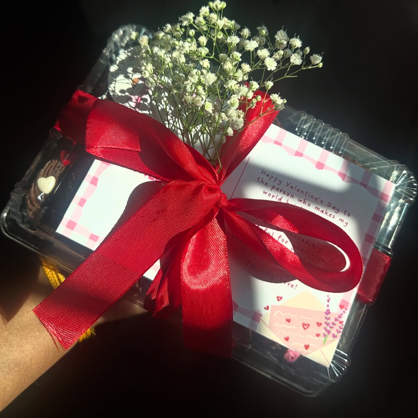 Gift box with red ribbon and flowers
