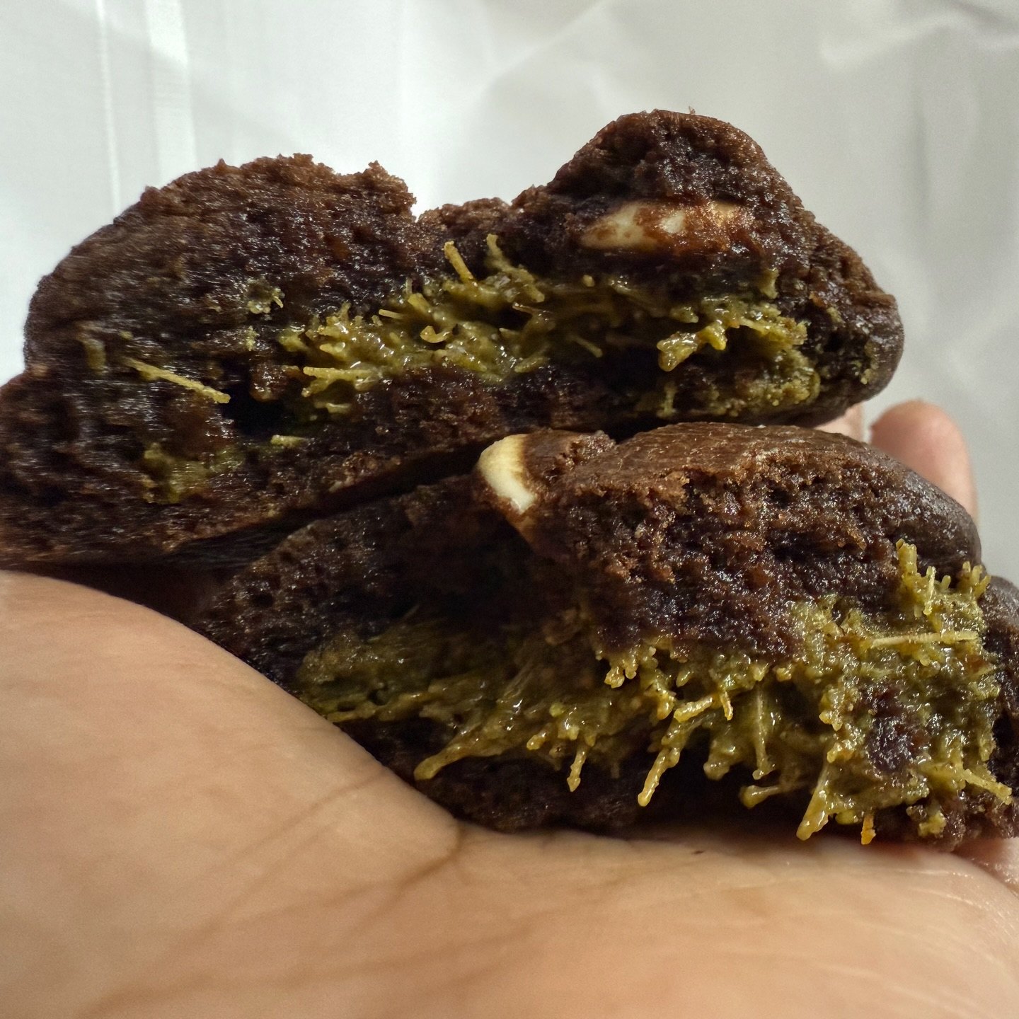 Dubai kunafa brownie broken open to show pistachio centre